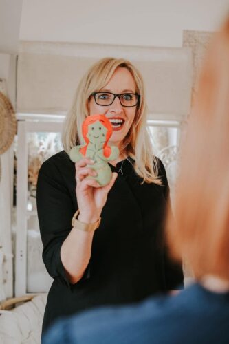 Vorständin Mandy hält eine Klara Kleeblatt-Figur in die Kamera.